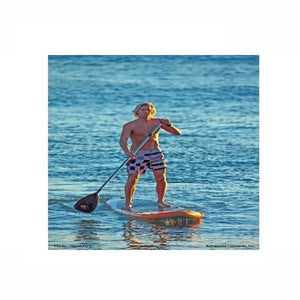 Man out paddling the orange and white Advanced Elements Hula 11 Inflatable SUP out on the ocean.