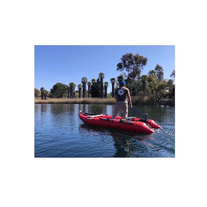 Bixpy Kayak Jet Motor is shown using the kayak outboard motor power pack connection and the Bixpy Universal Transom Adapter on a red inflatable pontoon boat.