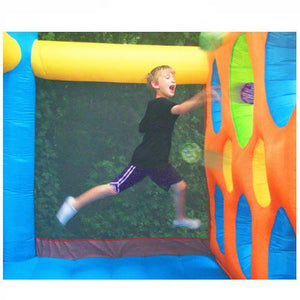 KidWise Jump'n Dodgeball Sports Bounce House in action dodgeball game.  Young boy jumping and throwing a neoprene ball through the openings in the inflatable partitioned wall.