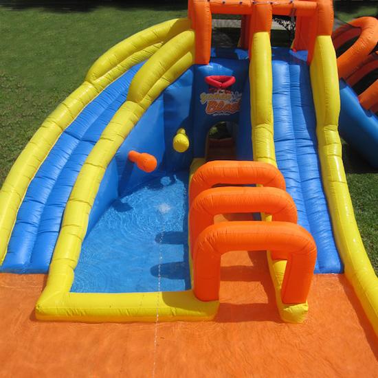 Front view of the KidWise Summer Blast Waterpark, showcasing slides, slippery tunnel, splash pools and basketball goal