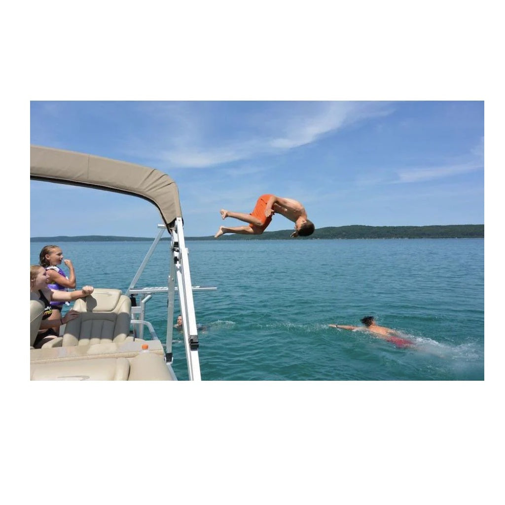 A teenager does a front flip off of the Lillipad Diving Board pontoon diving board.