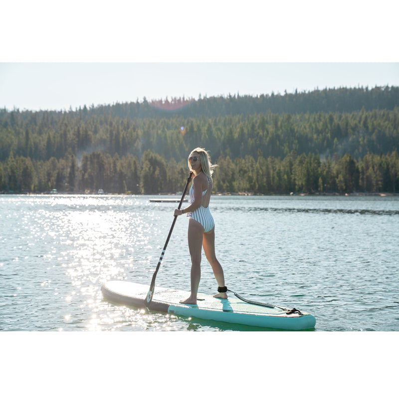 Royal Hawaiian SUP Mint-Black in the middle of the lake with a woman paddleboarding atop.