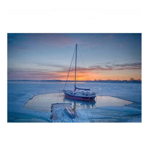 Power House Ice Eater for Sale melting ice around a sailboat moored out in a lake. The PowerHouse Ice Eater is melting ice all around the sailboat. The rest of the lake is frozen over showing how the PowerHouse Ice Eaters for Sale are the best dock deicers on the market.
