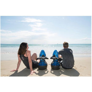 A couple sitting on the beach with their Yamaha RDS250 Seascooters.  The blue RDS250 Sea Scooters are sitting between them on the beach as they look out to sea.