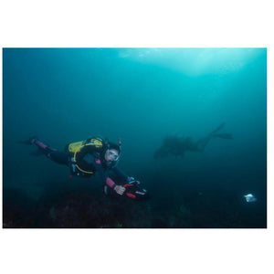 Yamaha RDS 300 Sea Scooter for Sale exploring underwater.  There is another diver shadowed in the background.  The front divers is using her Yamaha RDS300 near the bottom of the ocean.