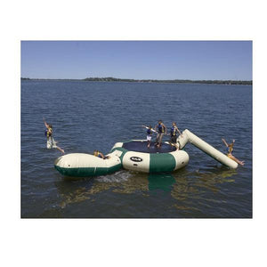 Kid flying off the yellow Aqua Launch on the tan and green Rave Bongo 15 Water Bouncer Water Park which also features a tan Aqua Slide.  The Rave Bongo Water Park is on a calm lake.