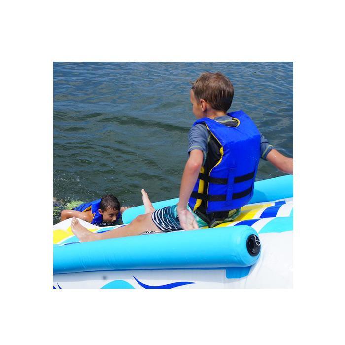 A young boy begins his slide down the rave inflatable dock slide into the lake.