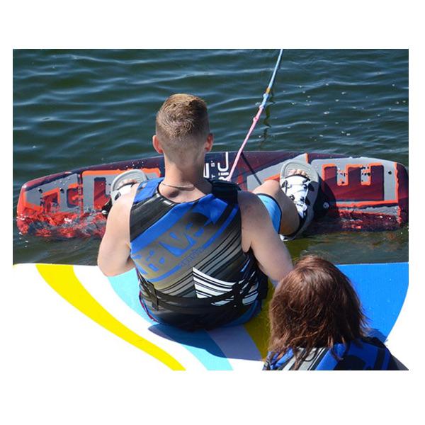 A kid preparing to launch off the Rave Water Whoosh Floating Water Mat on his wakeboard.