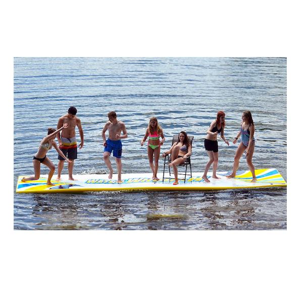 Overhead view of the white Rave Water Whoosh 15 Inflatable Water Mat with yellow border and yellow and blue waves coming from both ends of the rectangular inflatable water mat.  Overhead view of the Rave floating water mat on a white background. 