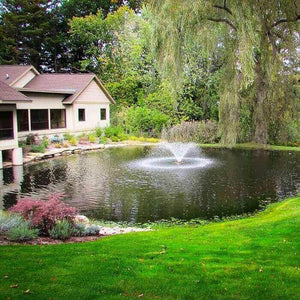 Scott Aerator DA-20 Display Aerator 1/3 Hp Floating Pond Fountain spraying a trumpet shaped water fountain spray in the middle of a neighborhood lake.  5ft tall floating fountain spray. Also known as a Small Pond Aerator Fountain.