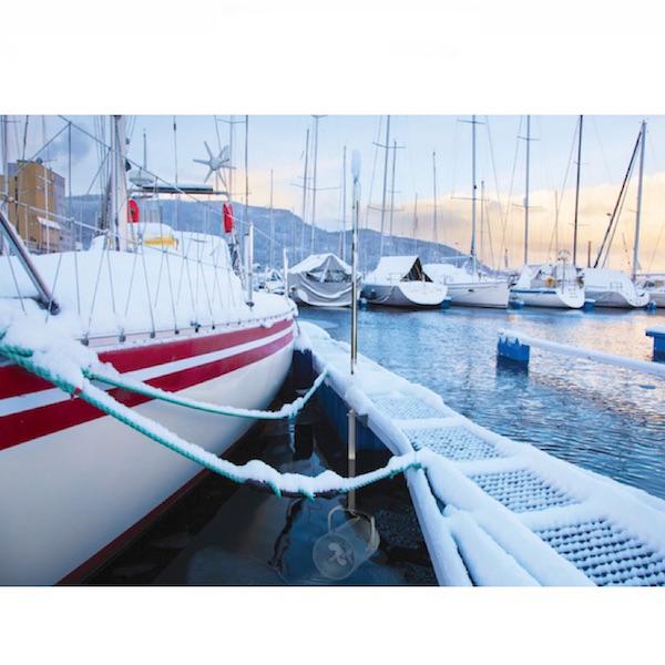 Scott Aerator Dock Mount De-Icer in use in a marina keeping the ice away.  The Scott Aerator Dock Mount DeIcer is attached to the dock and there is snow on the boats and dock, but the water is fine.