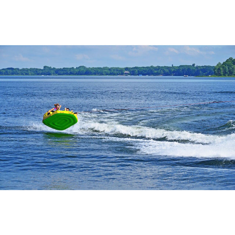 Green Rave #Stoked 2 Person Towable Boat Tube being pulled over a wave and through the air showing the green underbelly of the towable boating tube.