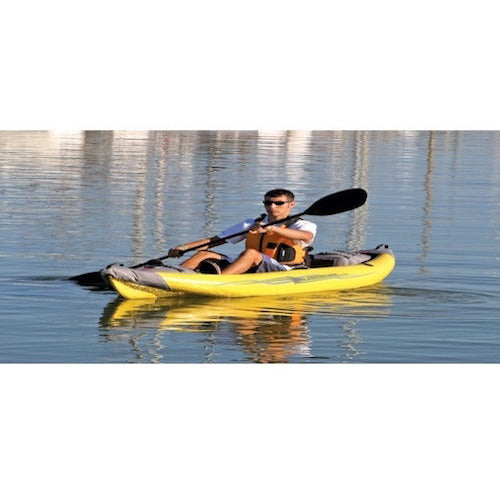 Man calmly paddling a yellow Advanced Elements StraitEdge 1 Person Inflatable Kayak on the open water.