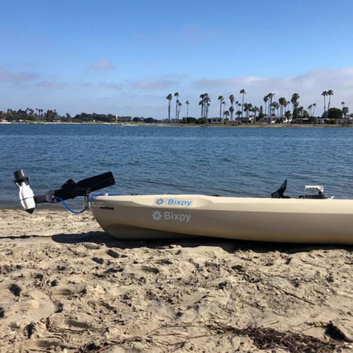 Bixpy Hand Steering Adapter in place on a kayak on the beach.