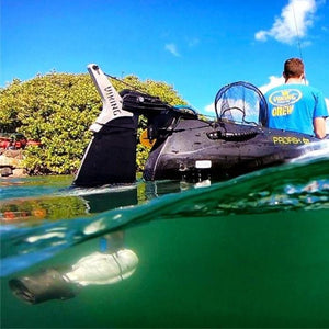 Read underwater view of the grey and black Bixpy Jet Thruster in use behind a kayak using he Bixpy DIY Adapter.  The Bixpy Kayak Jet Motor is fully in place and underwater.  The kayak outboard motor power pack is not visible here. 