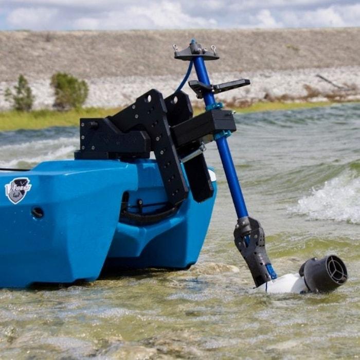 Bixpy Kayak Jet Motor Outboard Kayak Motor Kit is shown on the rear of a blue kayak using an Bixpy adapter.  The Bixpy Jet thruster is half in the water and half out, the water is very shallow, only several inches deep.