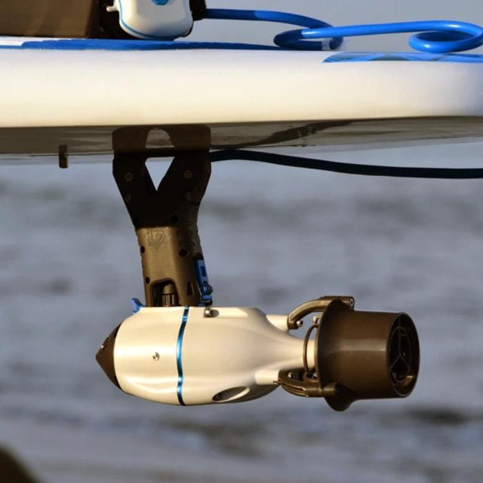 Bixpy SUP Adapter with Flip and Lock Fin Box. The Adapter is solid black, it is connected to the black connection piece with a light blue cord.