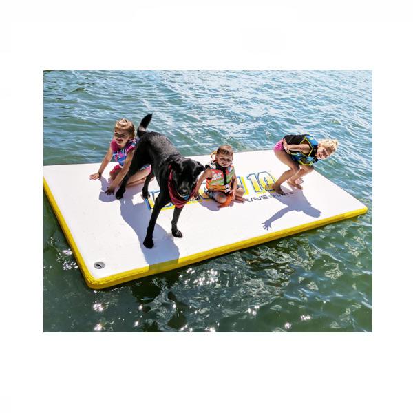 3 Young kids sitting on the Rave Water Whoosh 10 Floating Water Mat with their dog, floating on the lake.  The top of the water mat is almost all white with yellow letters and edging.