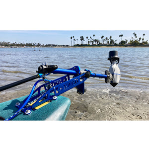 Bixpy Universal Power Pole Kayak Adapter is shown hinged out of the water while docked on the shore. Only the back portion of the kayak is visible.