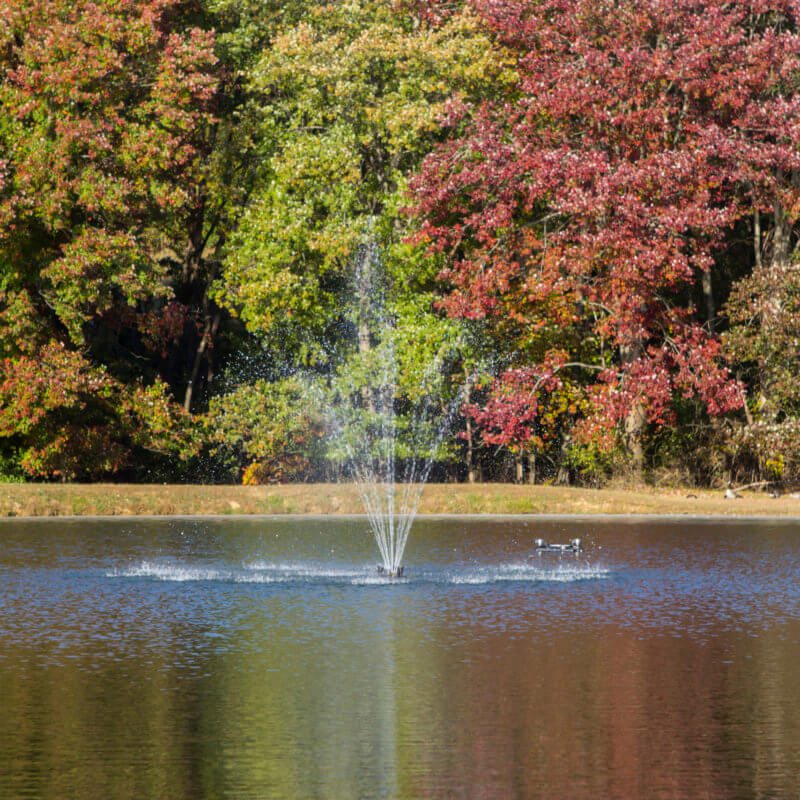 Floating Olympus Fountain in the middle of a pond by a park-like setting