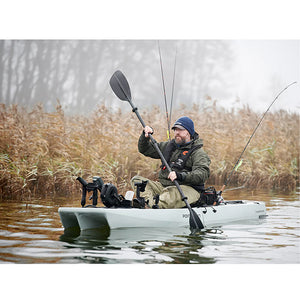 This is the Grey KingFisher Solo Modular Fishing Kayak in action out in the lake with a person paddling on it.