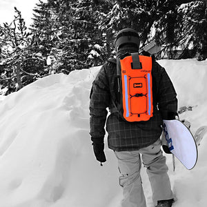 This shows the orange PRO-VIS Backpack on a man's back on his way to snowboard.