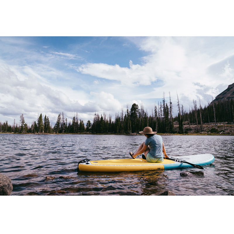 Paddleboards 11'0 Pop Up Inflatable SUP in the middle of the lake with a person sitting on it.