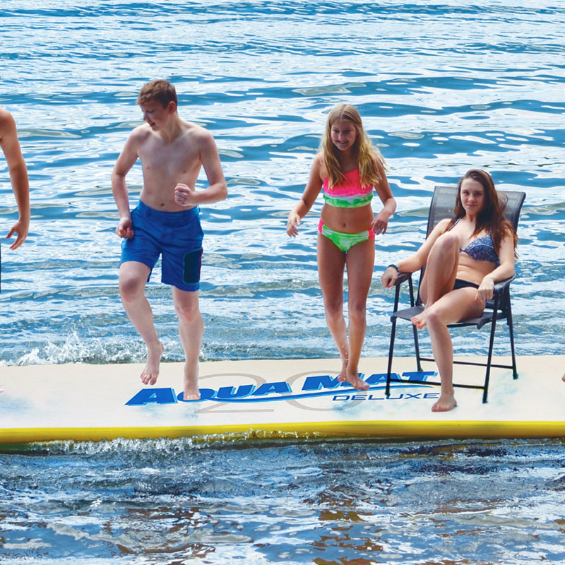 Aqua Mat Deluxe 20&#39; on the water with multiple people on it, 1 of them sitting on a chair.